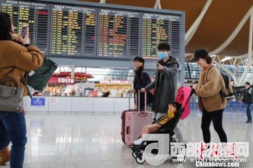 旅客帶著孩子前往辦票柜臺(tái)辦理登機(jī)手續(xù)?！∫罅⑶?攝