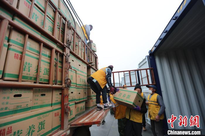 圖為鐵路裝卸作業(yè)人員正在將云南特色農產品裝入集裝箱?！詈?攝