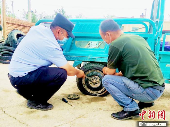 賽旦與民警共同維修三輪摩托車?！∫懒窘?攝