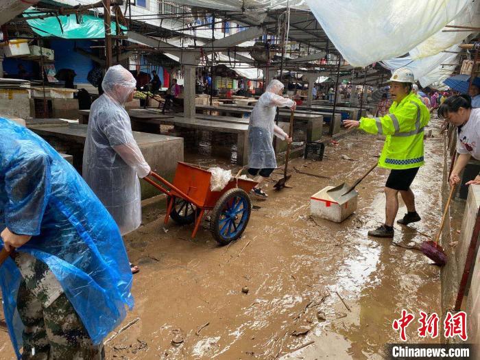圖為7月26日，暴雨引發(fā)的洪水過境后，重慶萬州區(qū)分水鎮(zhèn)政府干部職工及志愿者清掃淤泥和垃圾?！　≈貞c萬州區(qū)委宣傳部供圖 攝