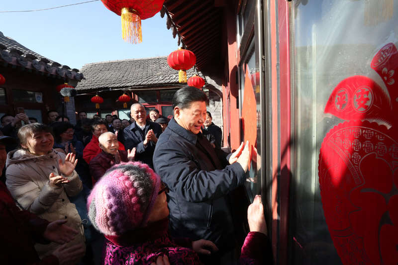2019年2月1日上午，習(xí)近平在北京前門東區(qū)草廠四條胡同32號院，高興地拿起一幅“?！弊?，親自貼到門上，給這里的老街坊們拜年。新華社記者 鞠鵬 攝